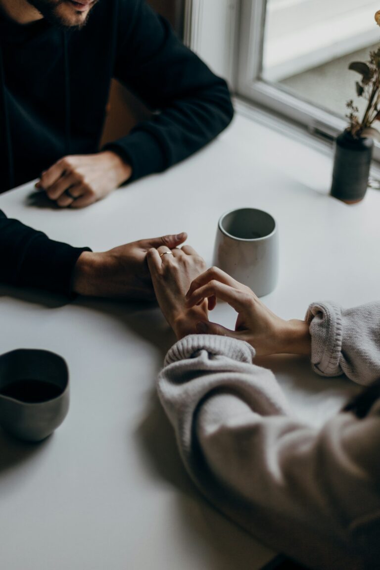 Home 65 A couple holding hands across a table, a small bid for connection