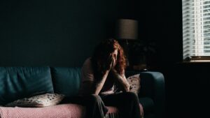 A woman sitting alone, carrying the household mental load